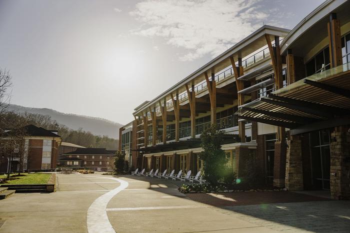 a building with a road and trees